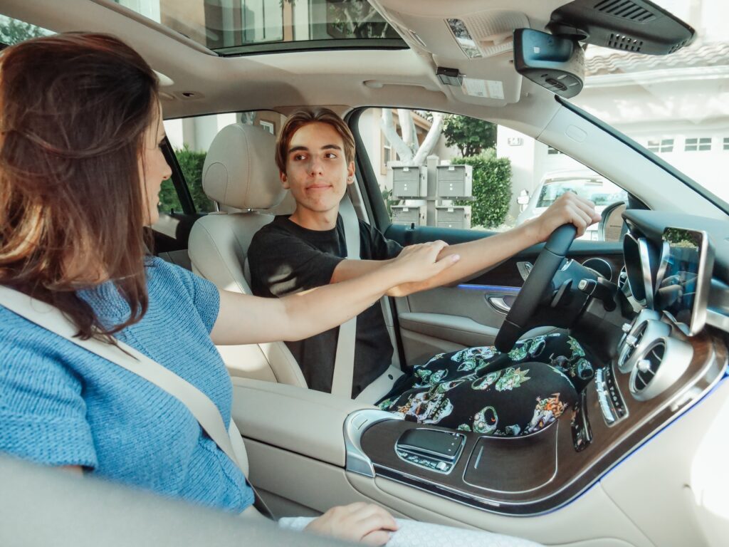 Young male teen behind the wheel with parent in passenger seat