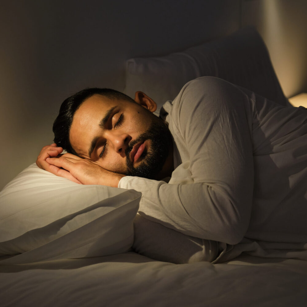 Man is sleeping soundly in his bed with a peaceful expression on his face